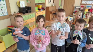 Dzieci prezentują wykonane przez siebie papierowe motyle